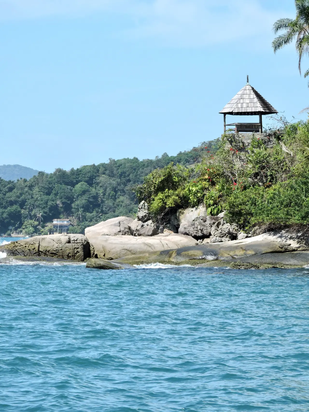 Gazebo above granite rocks and clear blue water at Haad Rin on Koh Phangan