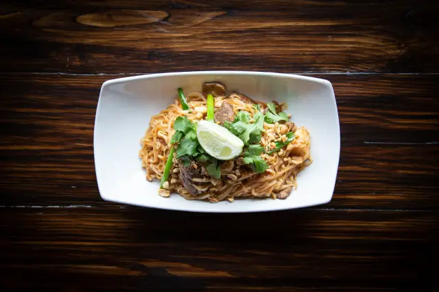 Translate food-tour dish names with an ingredient and source record