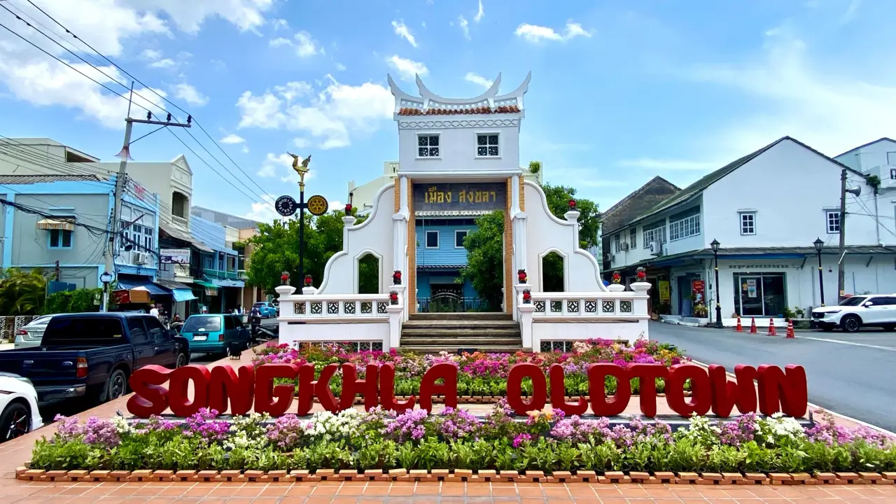 White Songkhla old-town gateway between heritage streets in bright daylight
