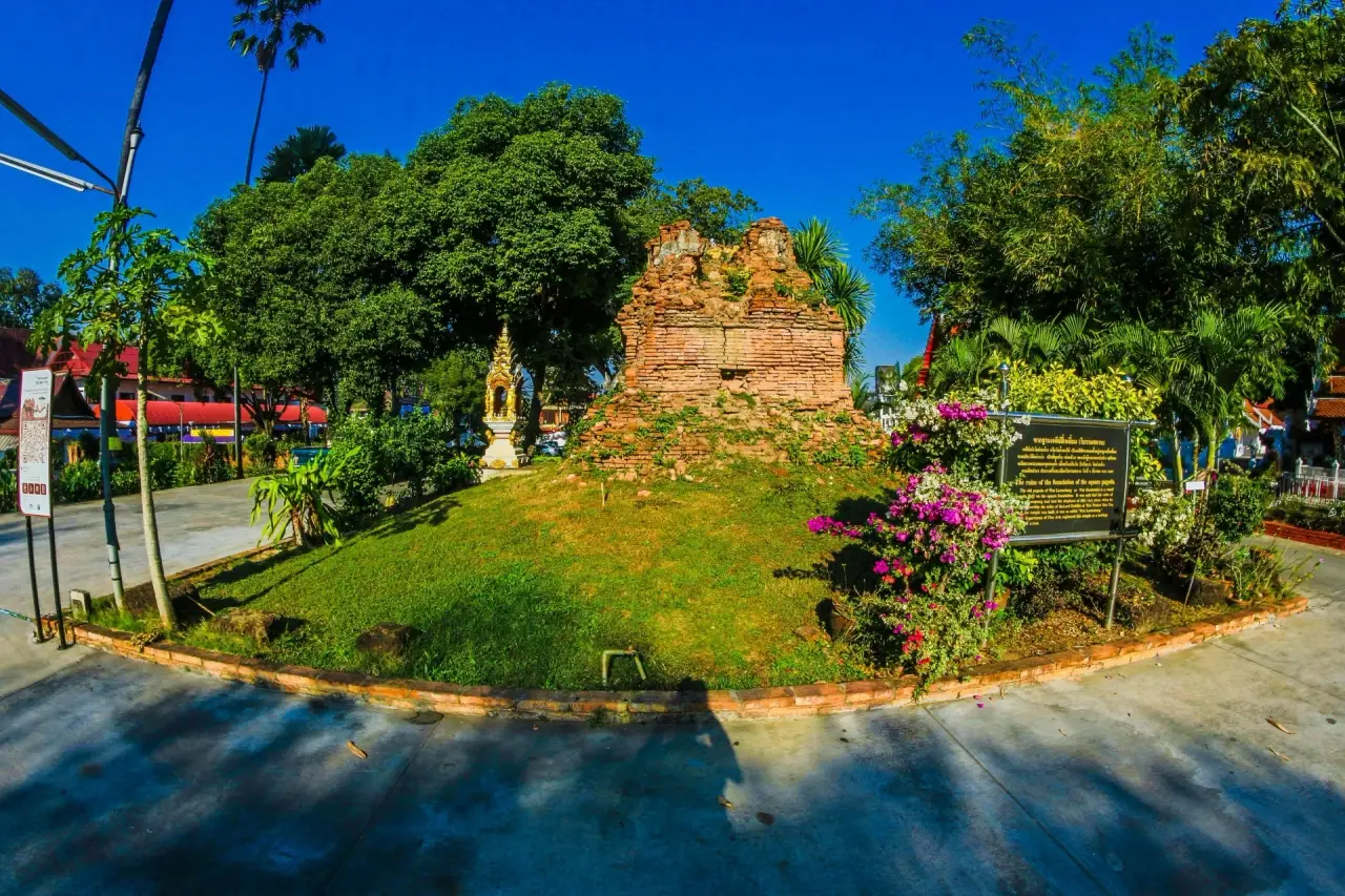 An old brick chedi on a grassy mound at Wat Phra Kaeo Don Tao in Lampang.