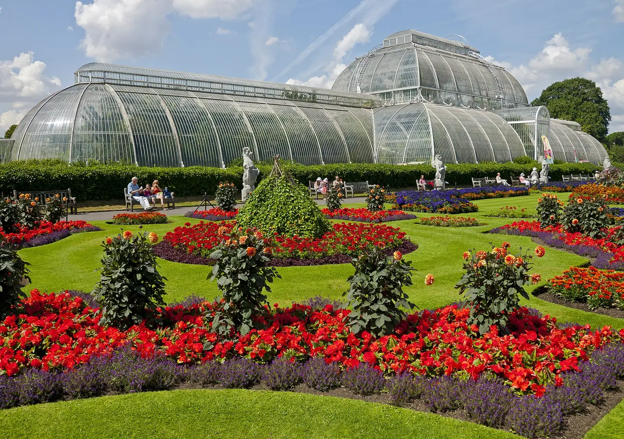 Colourful flower beds in front of the Palm House at Kew Gardens in London