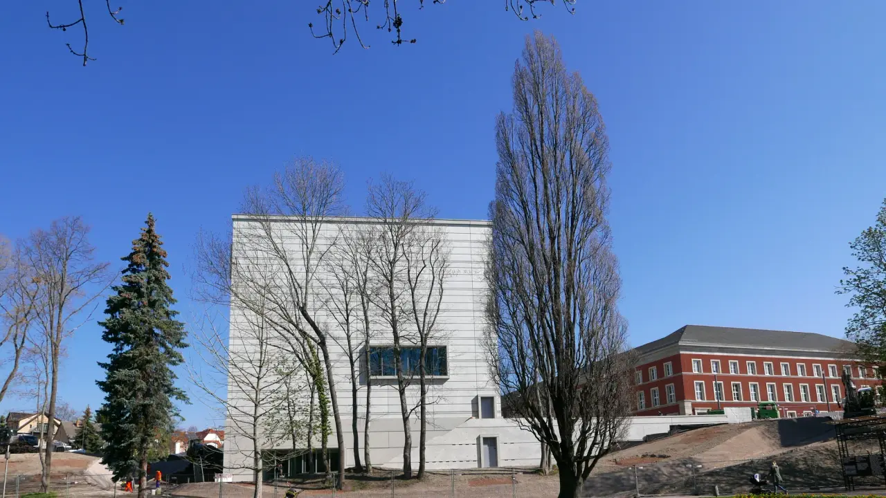 Das Weiß Bauhaus Museumsgebäude zwischen Bäumen und Freiflächen in Weimar