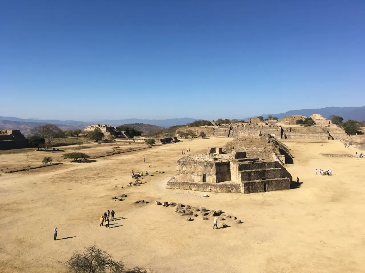 The main plaza and stone buildings at Monte Albán under a clear blue sky in Oaxaca, Mexico
