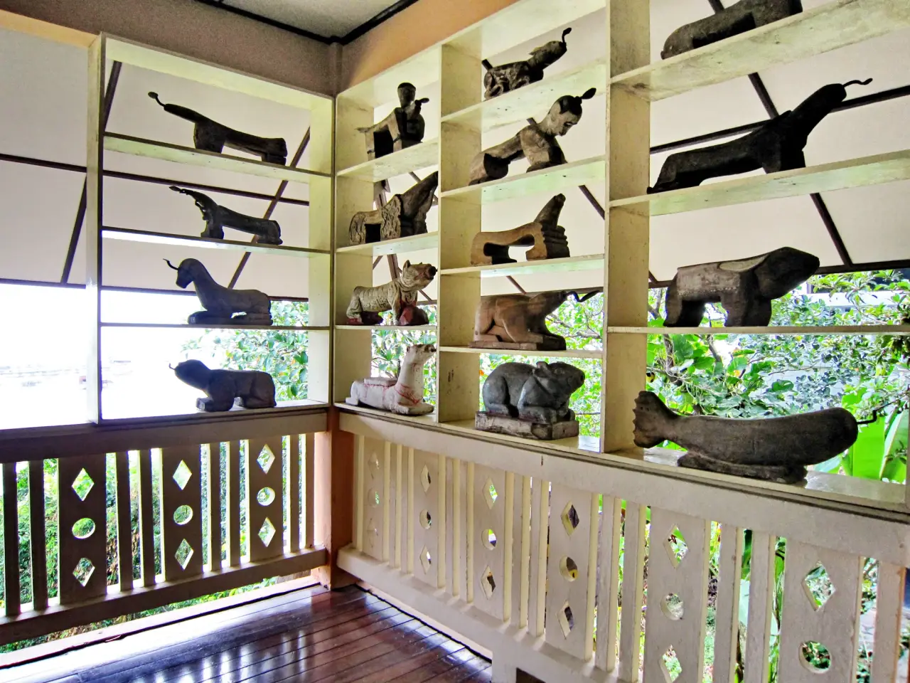 Carved animal-shaped coconut graters are displayed in a naturally lit gallery at the Institute for Southern Thai Studies on Koh Yo.