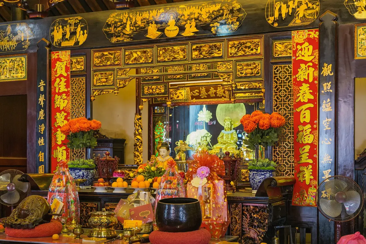 Un autel avec décoration en or, fleurs et offrandes à Cheng Hoon Teng l'intérieur du temple à Melaka.