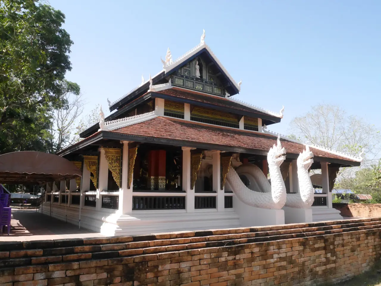 Salle de temple aux toits étagés et rampes d’escalier en forme de naga blancs à Wat Phra That Chae Haeng, Nan