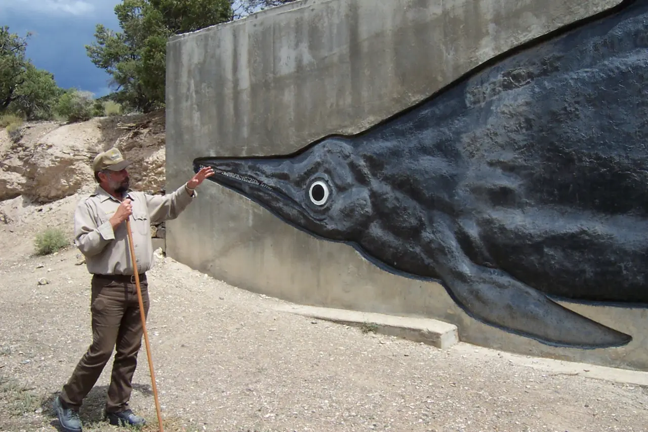 A guide speaking beside a large outdoor wall painting