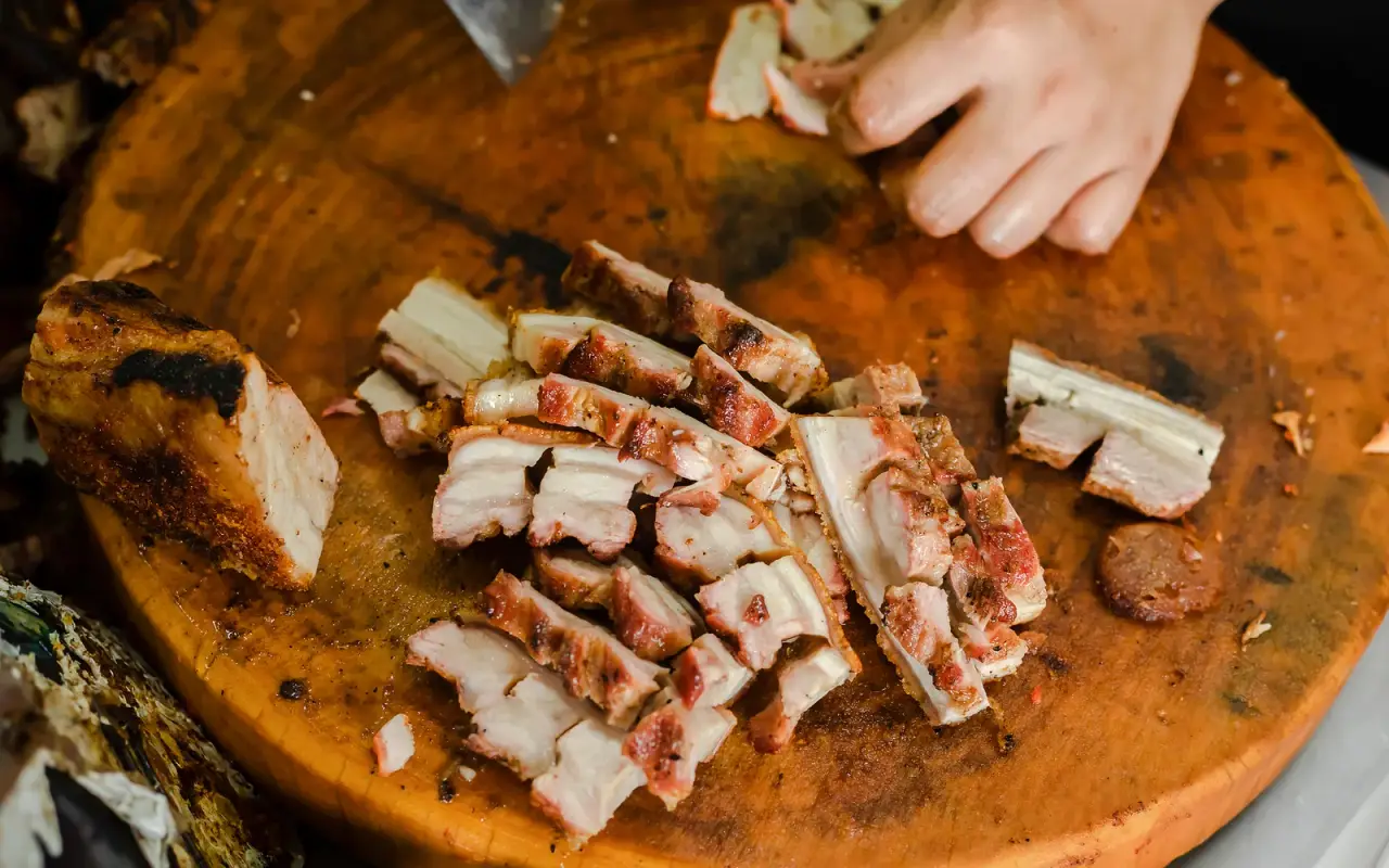 Thai-Chinese barbecued pork being sliced at a food stall