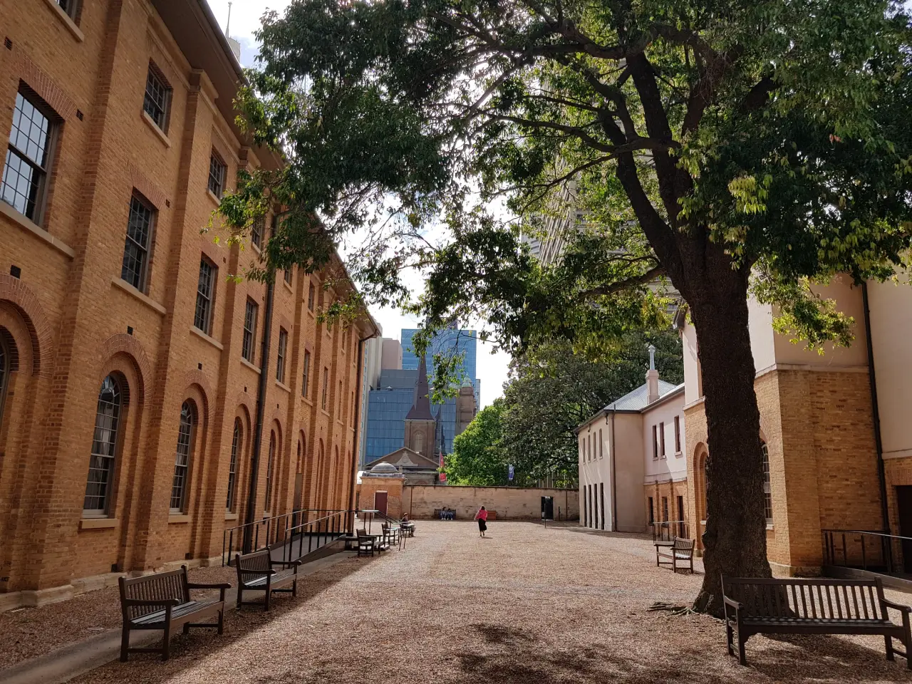 Brick courtyard buildings and a shaded walkway at Hyde Park Barracks in Sydney.