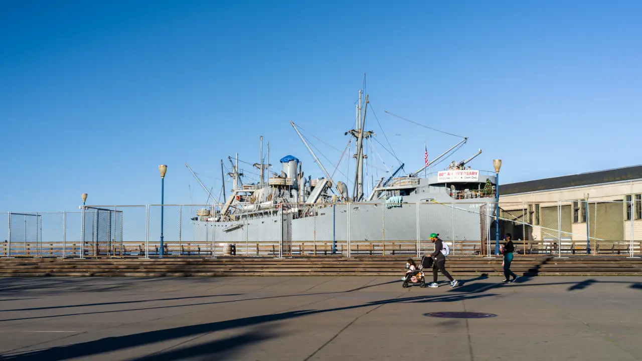 People walk along San Francisco’s waterfront beside the historic SS Jeremiah O’Brien at Pier 45.