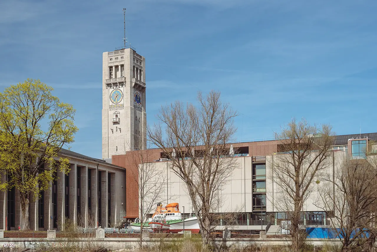 The clock tower and museum buildings of the Deutsches Museum on Munich’s Museum Island beneath a blue sky