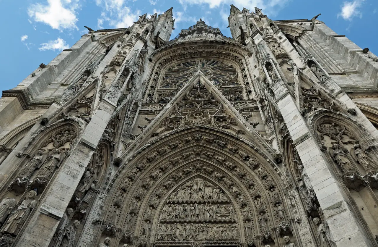 Portail sculpté et détails sculpturaux de Rouen Cathédrale sous un ciel bleu