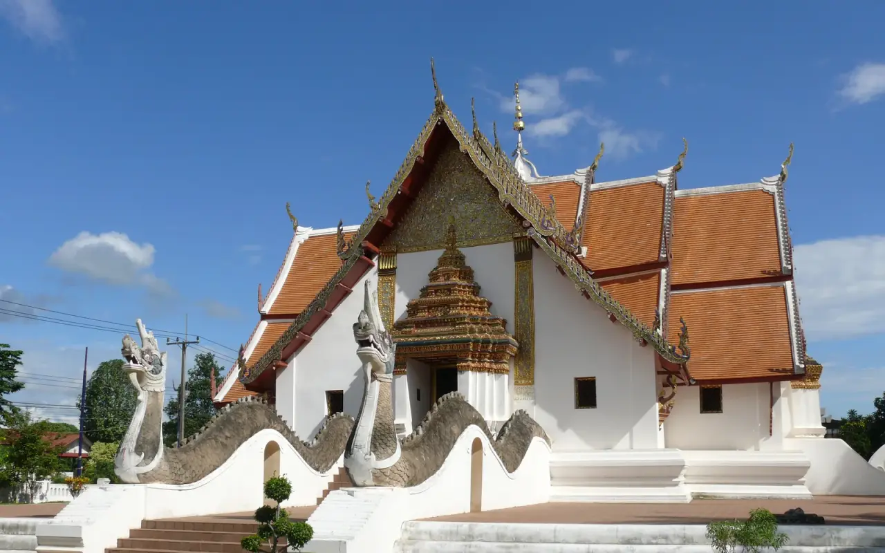 Wat Phumin and its ornate rooflines beneath blue sky in Nan