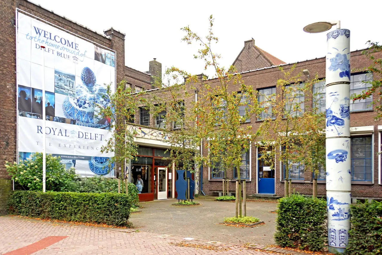 The visitor entrance and blue-and-white ceramic decoration around a planted brick courtyard at Royal Delft in the Netherlands.