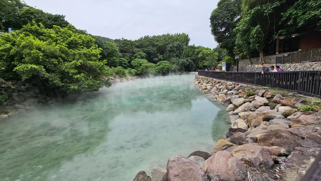 Pale turquoise geothermal water and steam beside the walkway at Thermal Valley in Beitou, Taipei