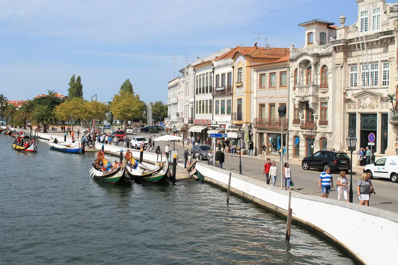 Colourful moliceiro boats moored along Aveiro’s canal beside ornate waterfront facades