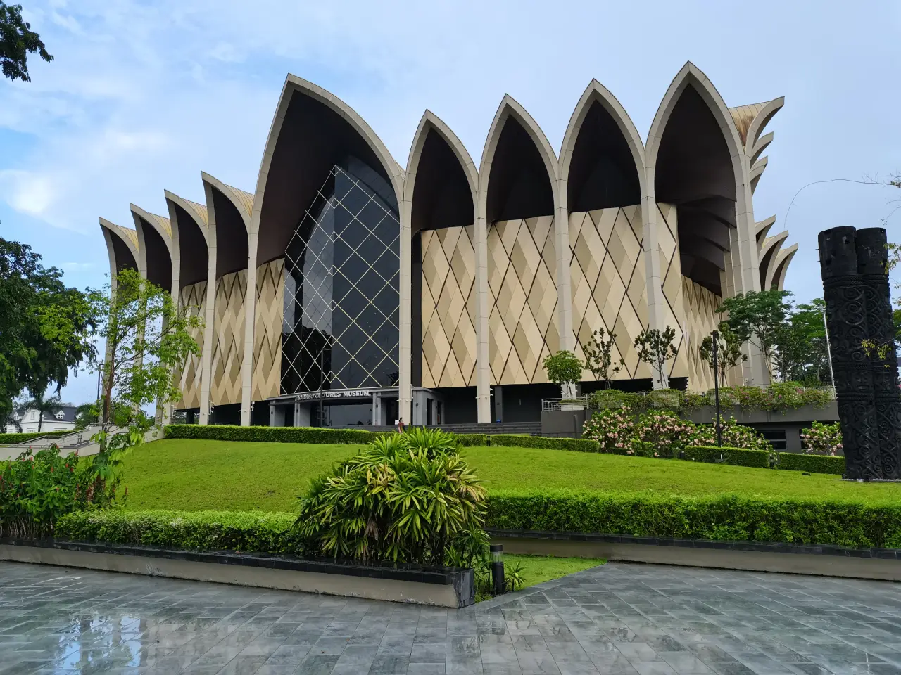 Pointed gold roof forms above the garden at Borneo Cultures Museum in Kuching.