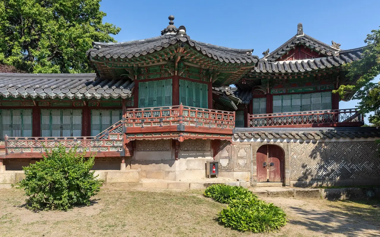 The complete Samsamwa pavilion roof and stone base at Changdeokgung Palace beneath a clear blue sky in Seoul