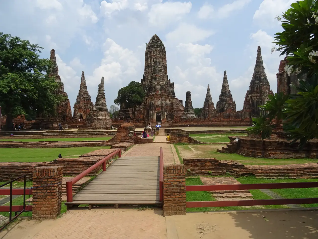 Central prang and surrounding towers of Wat Chaiwatthanaram in Ayutthaya under a bright daytime sky.