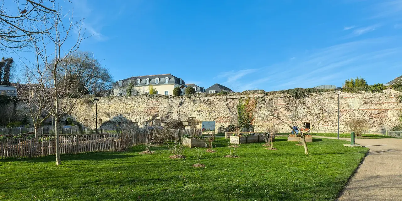 Historic stone walls and a sunny green garden at Jardin des Vikings in Tours