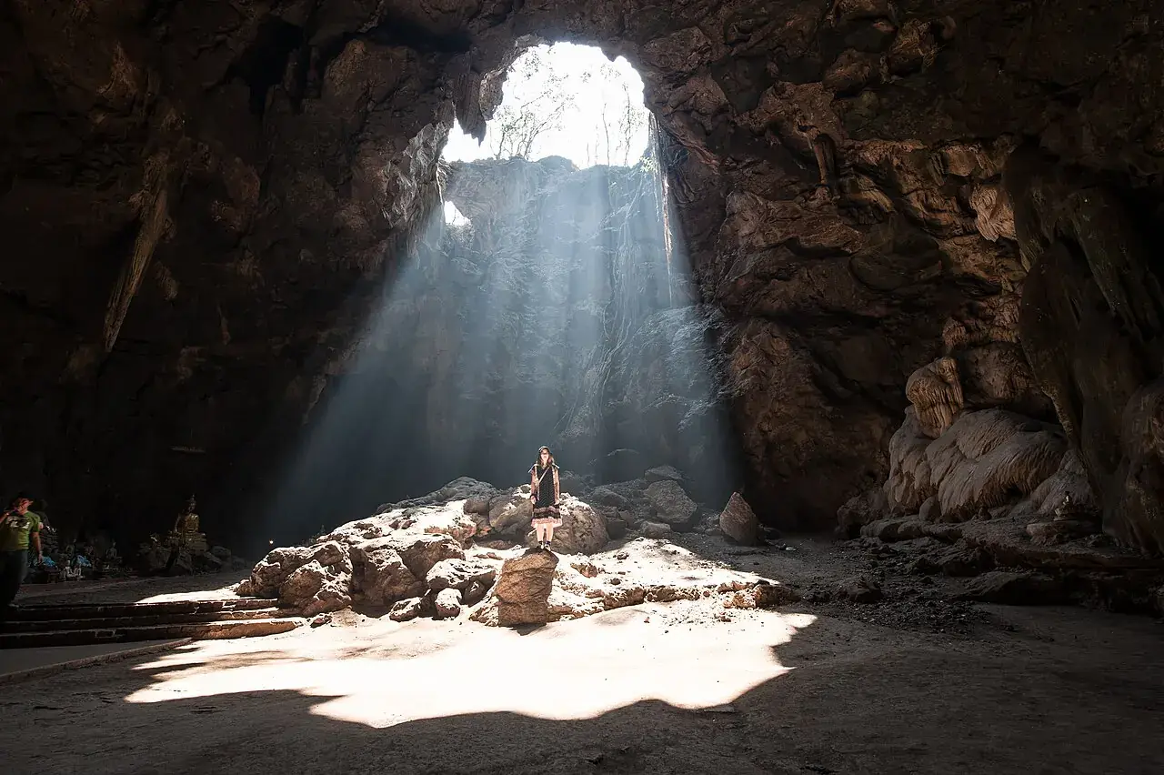 Sunbeams illuminating Buddha statues inside Khao Luang Cave in Phetchaburi