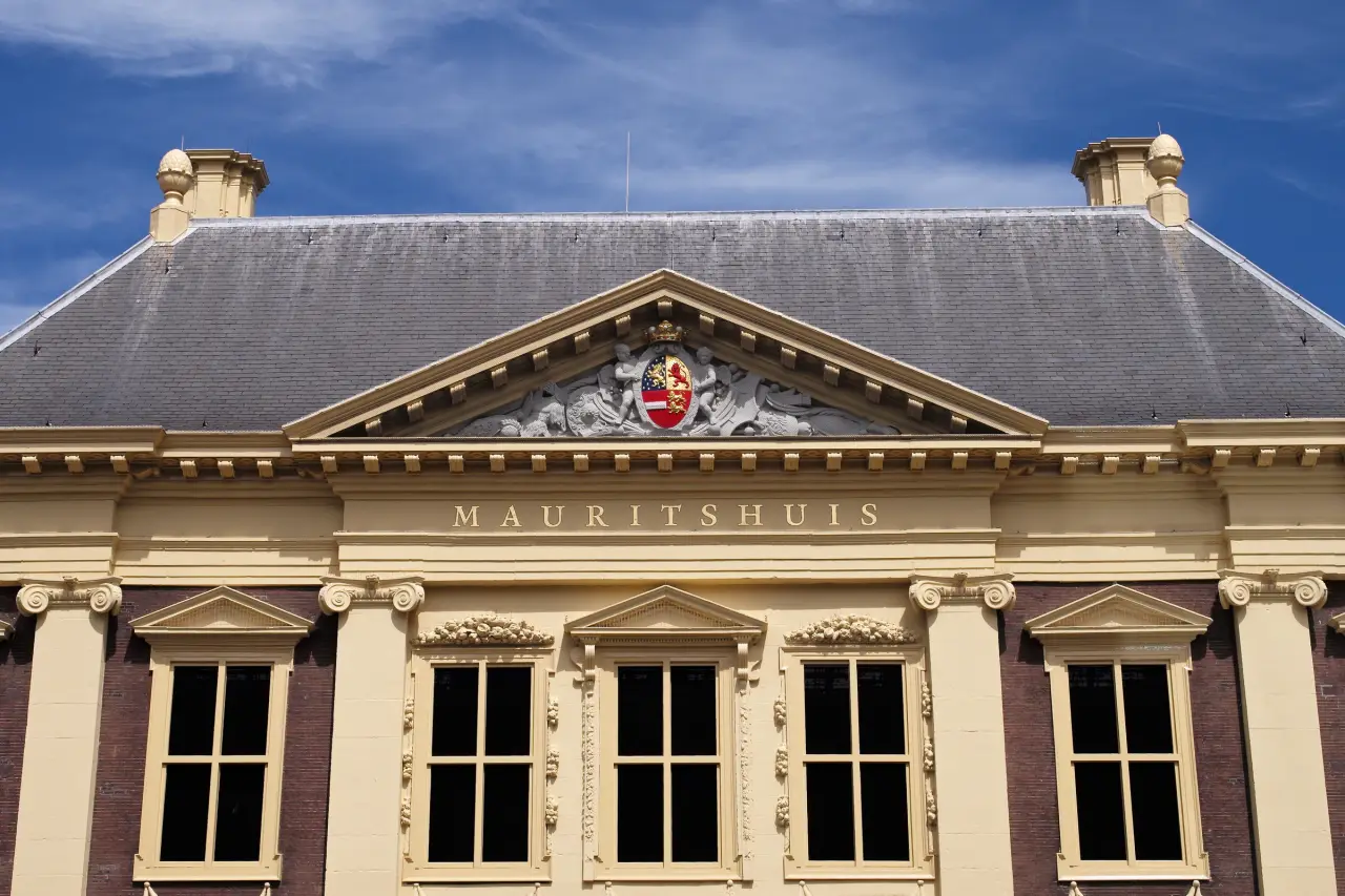 แสงแดดบนหน้าจั่วกลาง ตราอาร์ม และชื่อพิพิธภัณฑ์บนด้านหน้าของ Mauritshuis ในกรุงเฮก