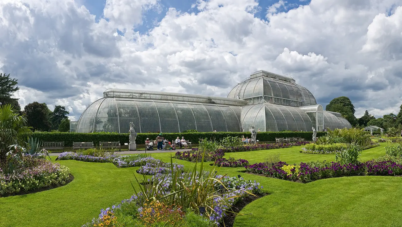The complete Palm House and colourful flower beds at the Royal Botanic Gardens, Kew