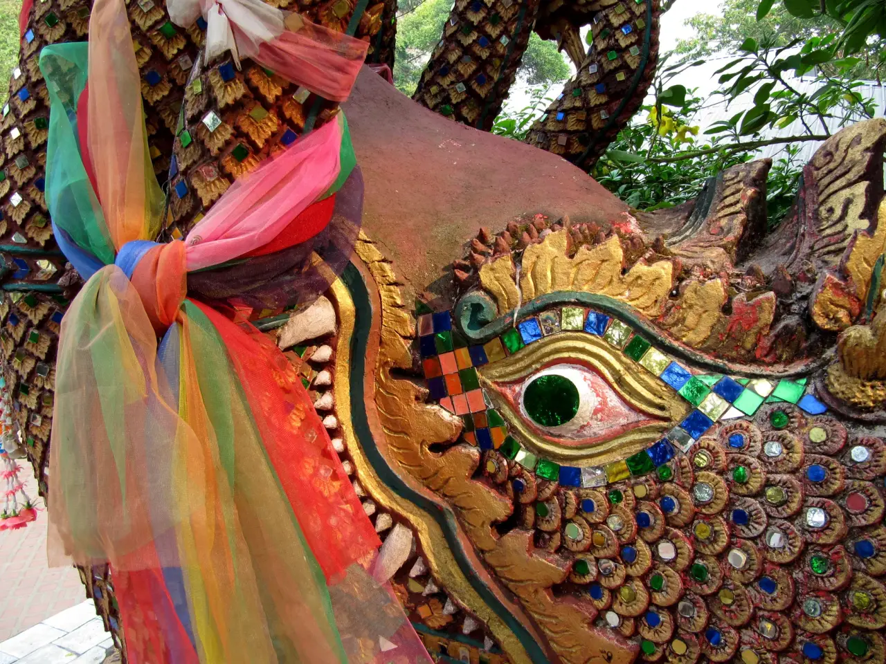 A colourful mosaic naga-eye detail beside the staircase at Wat Phra That Doi Suthep.