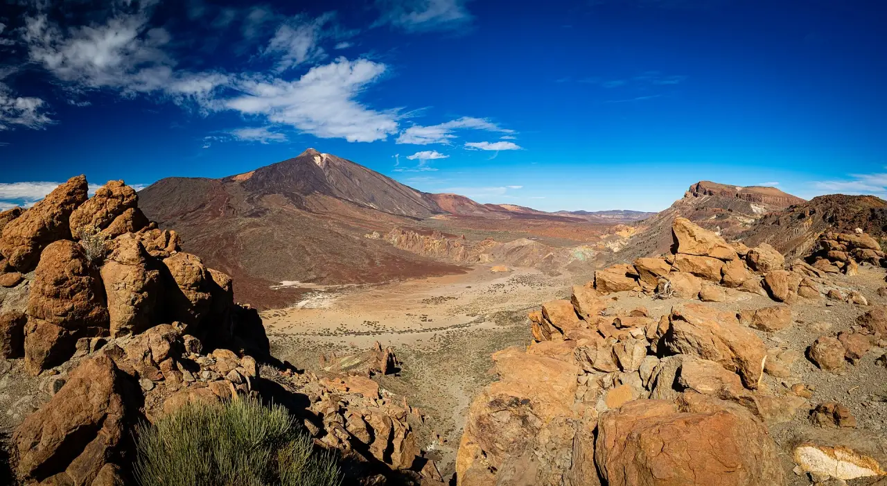 Teide and the volcanic landscape of Tenerife beneath a vivid blue daytime sky