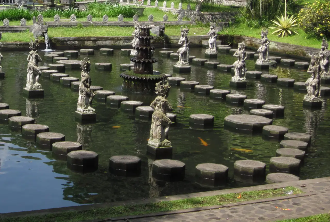 Stepping stones across a pool and a small fountain at Tirta Gangga in Bali.