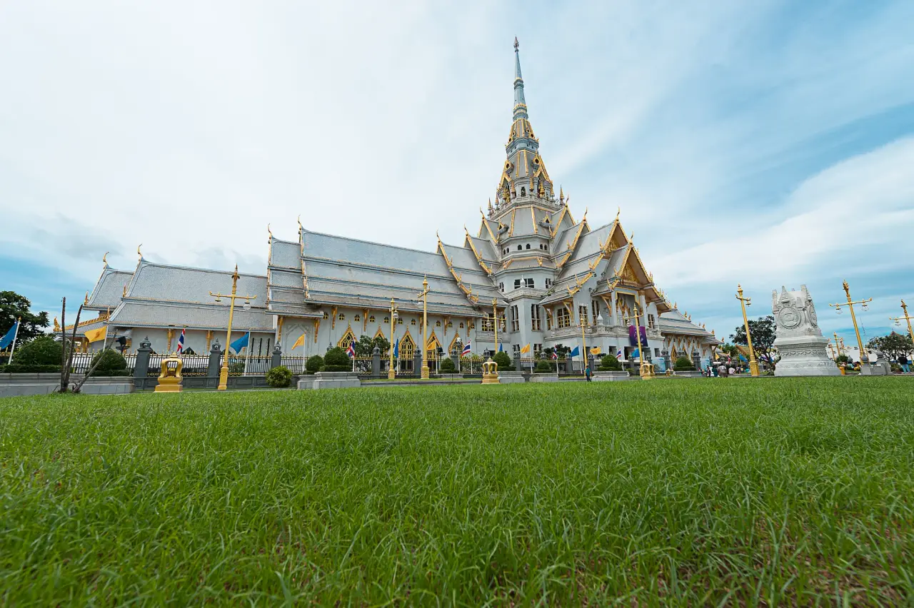 Wat Sothon temple avec sa flèche centrale ornée au-dessus d'une pelouse verte dans Chachoengsao