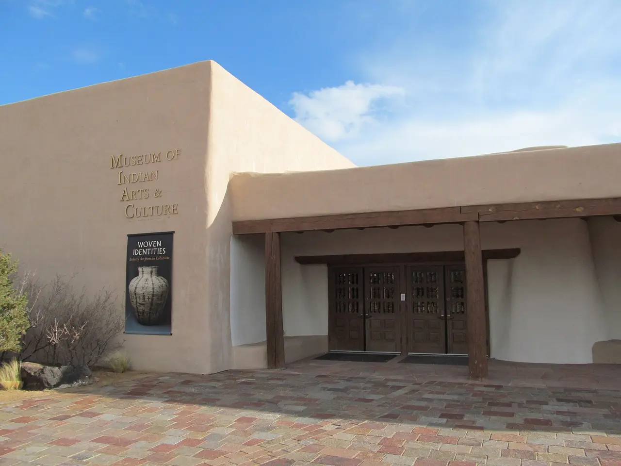 The warm adobe entrance facade of the Museum of Indian Arts and Culture on Museum Hill in Santa Fe