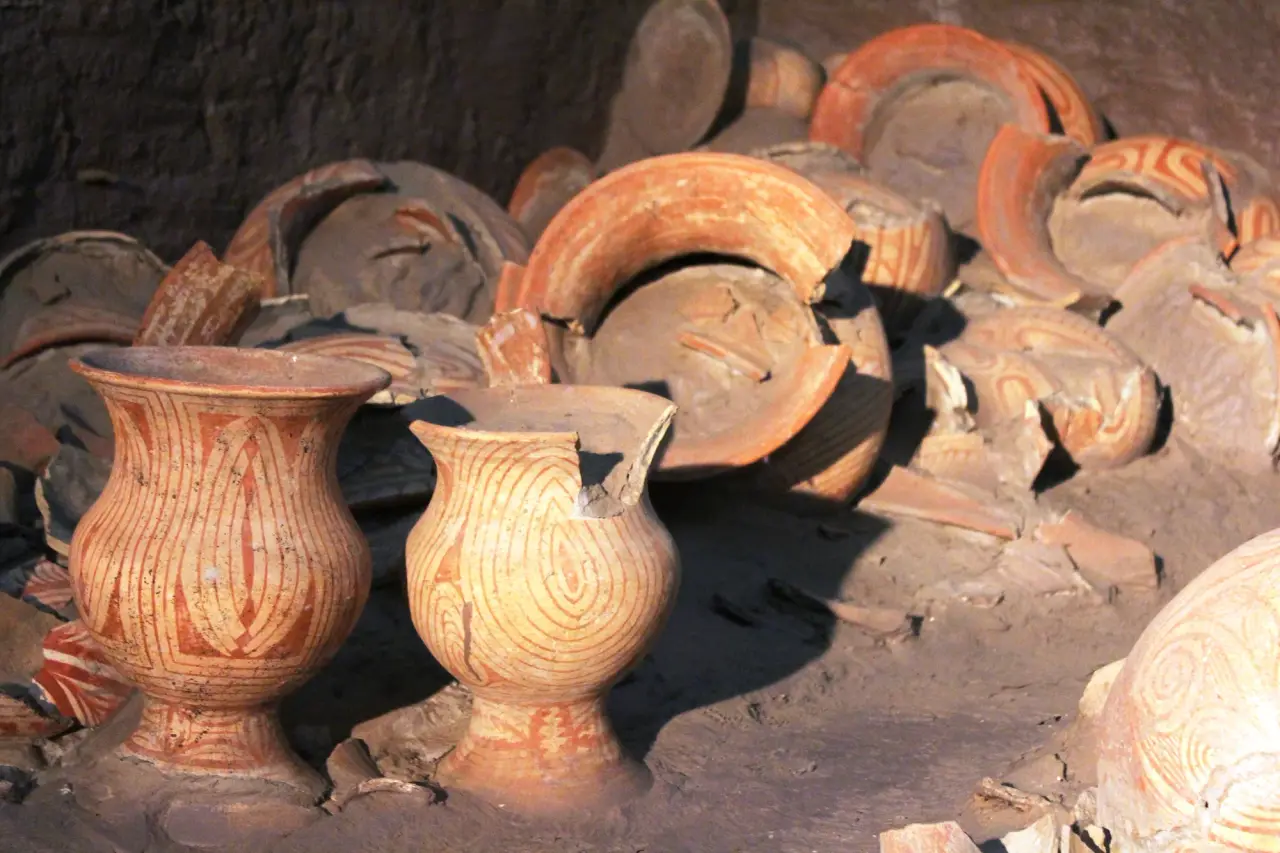 Red-painted pottery in a reconstructed excavation display at Ban Chiang National Museum