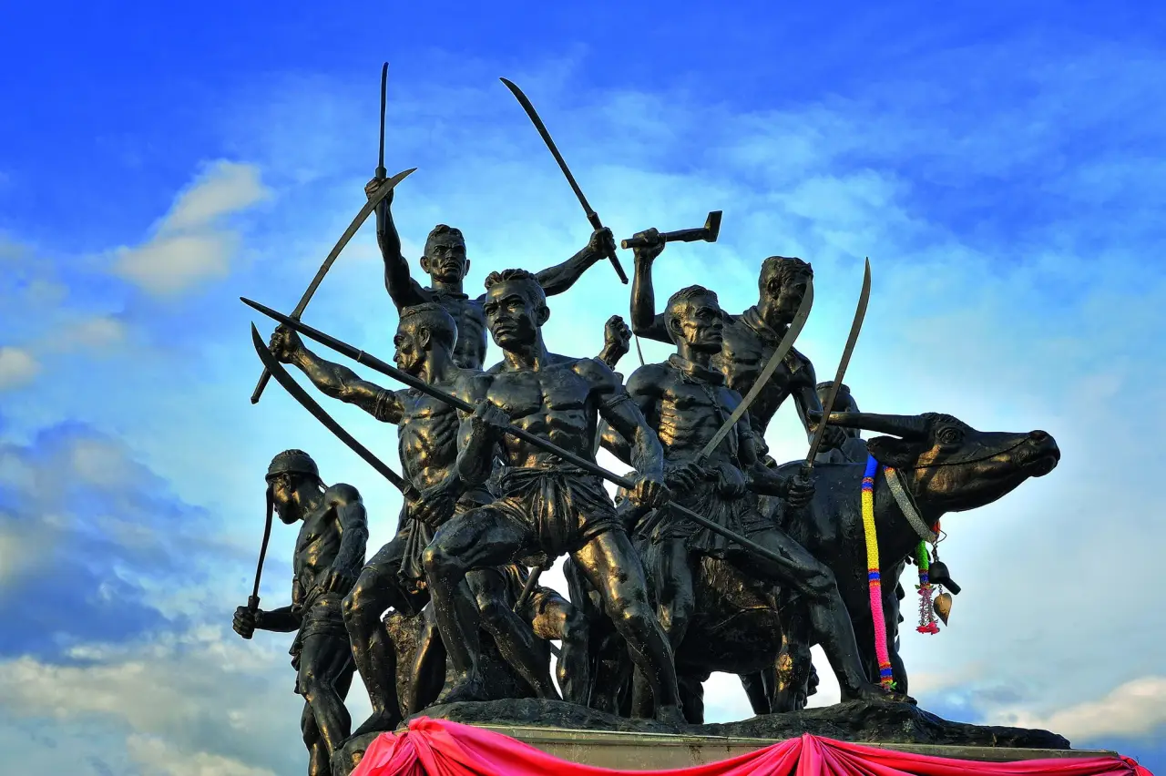 Bronze hero figures and raised weapons at the Bang Rachan memorial in Sing Buri
