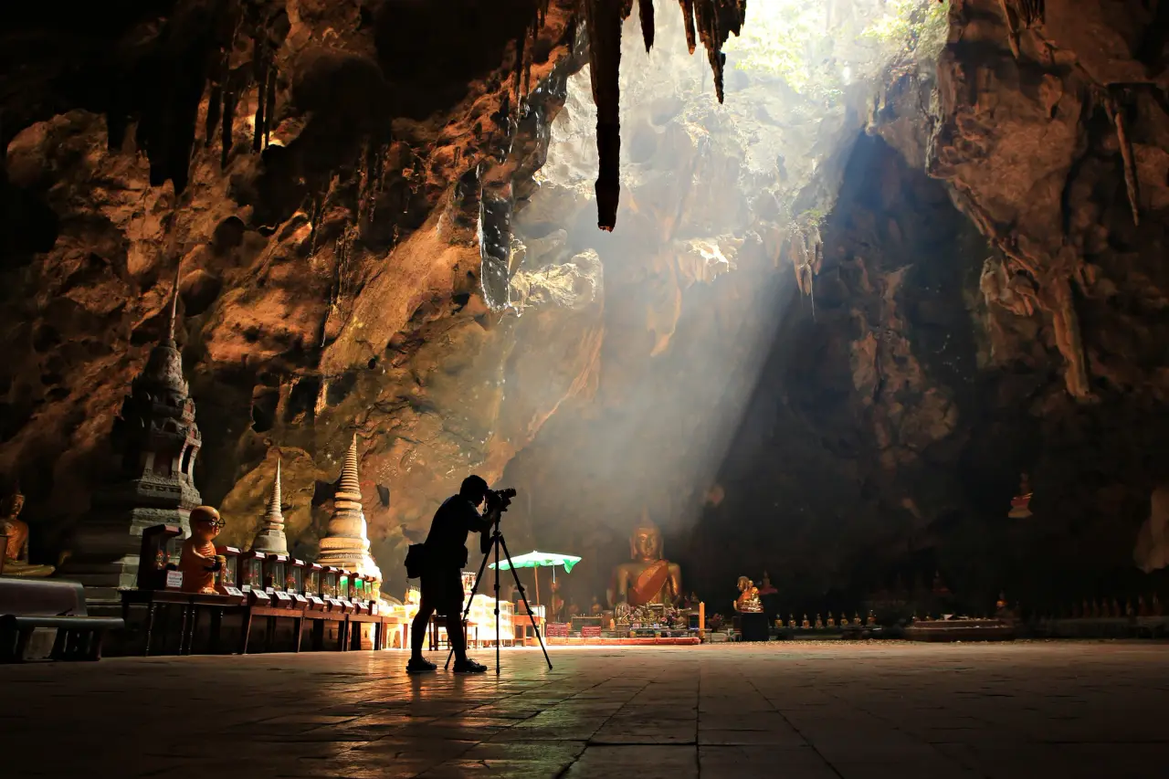แสงแดดเข้าสู่ห้องหินปูนของ Tham Khao Luang วัดถ้ําใน Phetchaburi